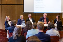 Fünf Teilnehmende der Podiumsdiskussion, Blick aus dem Publikum