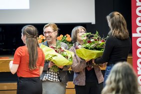 Zwei Technikantinnen überreichen den Koordinatorinnen einen Blumenstrauß