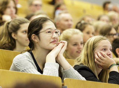 Mehrere junge Frauen, im Hörsaal sitzend, mit Blick nach vorne