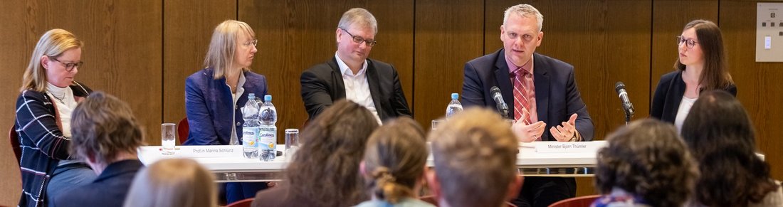 Podiumsdiskussion mit fünf Teilnehmenden, Blick aus dem Publikum