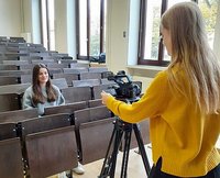 zwei junge Frauen beim Videodreh im Hörsaal