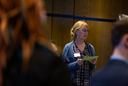Frau mit Moderationskarten in der Hand, Fokus mit Blick aus dem Publikum