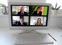 Bildschirm mit vier Personen in einer Konferenz