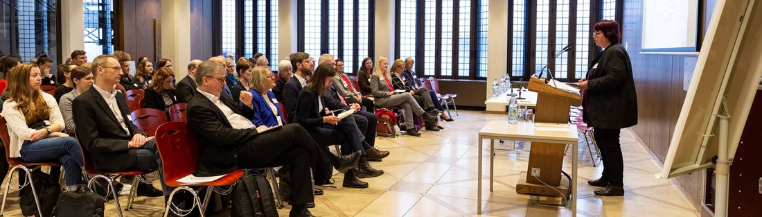 Blick von der Seite, Professorin Barbara Schwarze steht vor dem Publikum