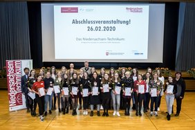 Eine Gruppe von Personen auf der Abschlussveranstaltung 2020 vor der Bühne